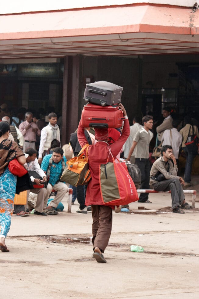 railway porter in red uniform outside varanasi junction station