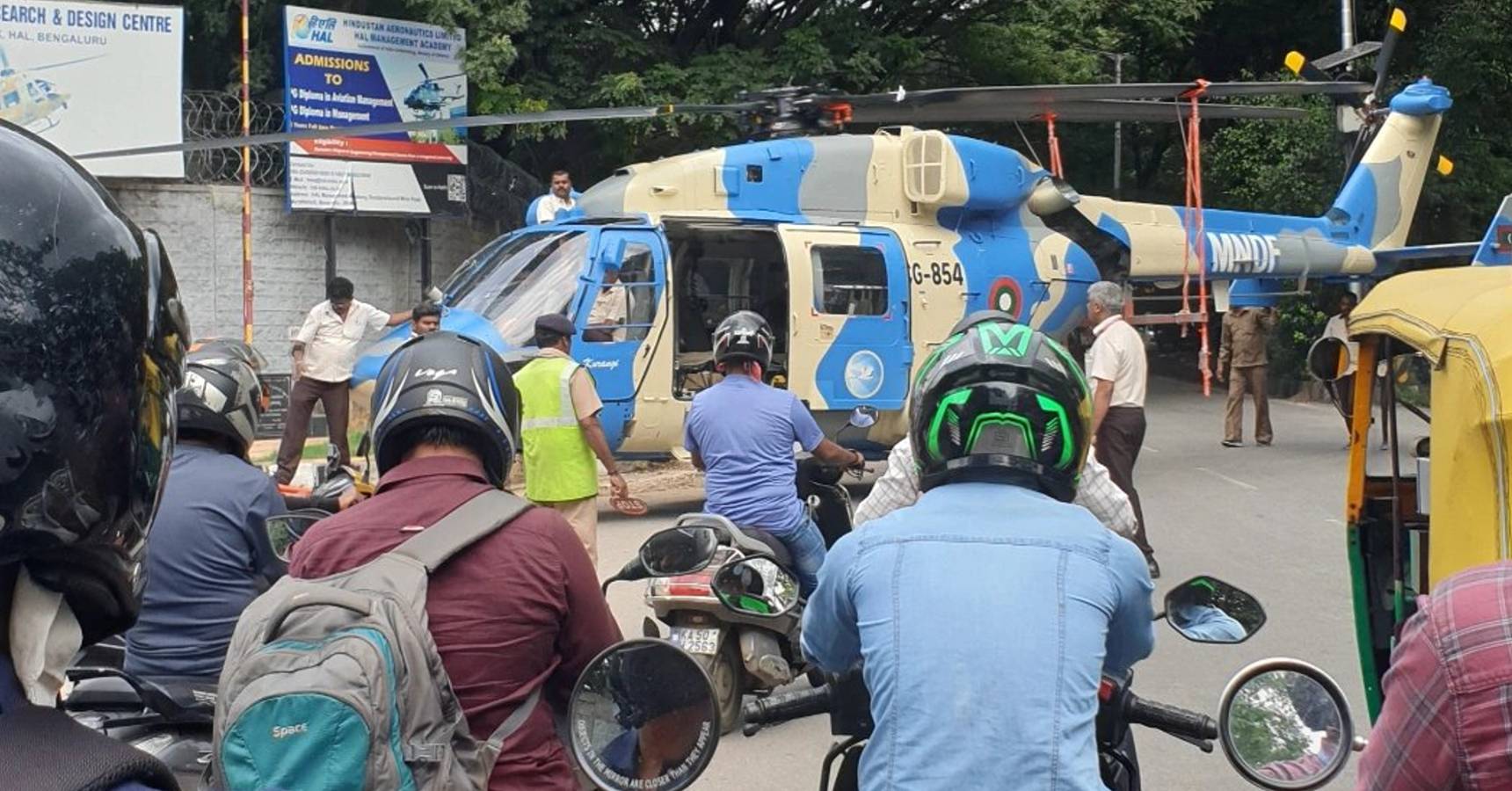 A large helicopter is parked on the street in this city