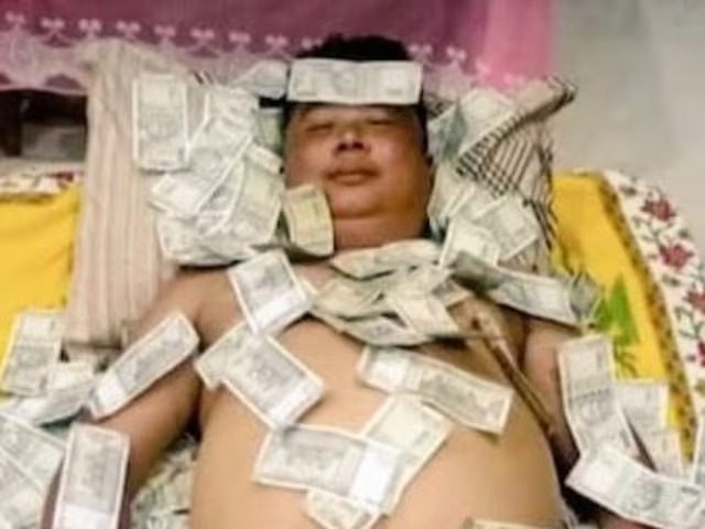 Leader lying on bed of money, viral photo.