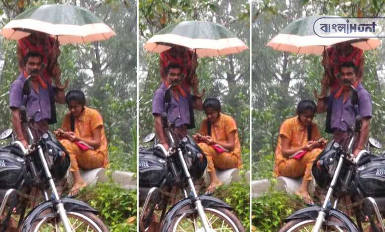 Girl immersed in reading online on the side of the road, father holding an umbrella over his head in the rain: Viral photo